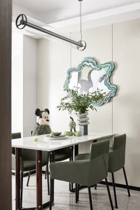 A modern dining room with a marble table, green leather chairs, and a decorative mirror.