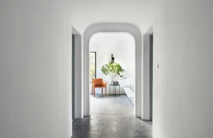 Modern minimalist interior with concrete flooring and a white couch.