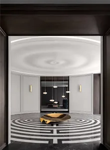 Modern entrance hall with a geometric marble floor pattern, highlighted by a sleek metal sculpture in the center.