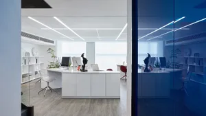A modern office space featuring white furniture and minimalistic design.