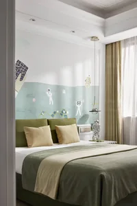 Minimalist bedroom with a green bed, white walls, and beige curtains.