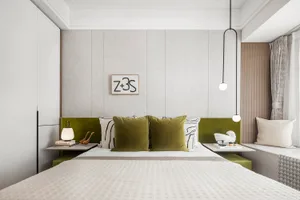 A modern bedroom with a textured cloth bedspread and green pillows.