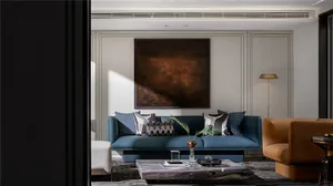 Modern living room with a dark blue leather sofa, marble coffee table, and artistic painting on the wall.