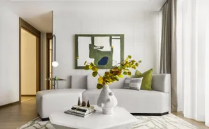 A modern living room featuring a white couch with green decorative accents and a green abstract painting on the wall.