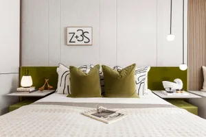 A modern minimalist bedroom featuring a bed with a green and white headboard, white bedding, and decorative pillows.