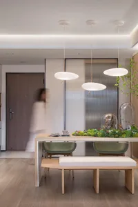 Modern minimalist dining area featuring wooden accents and upholstered seating.