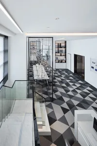 A minimalist office space with a black and white patterned floor, characterized by clean lines and a sleek, contemporary desi