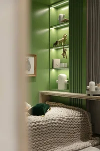 Children's room featuring green walls and a white desk with various decorative items and toys.
