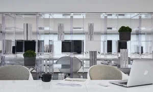 A modern workspace featuring glass shelves and minimalist design.