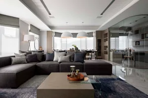 Modern living room featuring a comfortable fabric sofa adorned with various colored pillows, a glass coffee table, and a slee