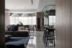 A modern living room with marble flooring, wooden accents, and glass elements.
