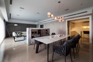 A stylish modern dining room featuring a marble table and contemporary furniture.
