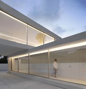 Modern residential home featuring glass and concrete materials.