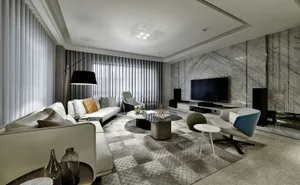 A modern living room with marble accent walls and leather furniture.