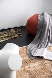 A modern living room featuring a cozy rug and textiles