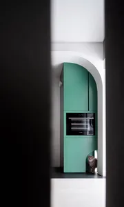 A modern kitchen with teal cabinets and an oven.