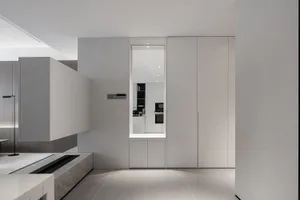 Modern minimalist kitchen with white cabinets and sleek design.