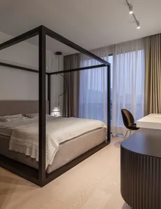 A modern bedroom featuring a frame bed with a minimalist design and a neutral color palette.