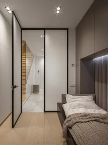 Modern bedroom featuring wooden flooring and marble walls.