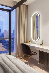 Modern minimalist bedroom with a sleek desk, upholstered chair, and large window overlooking the cityscape.
