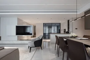 Modern minimalist living room, dining area, and kitchen integrated into a single space with sleek, clean lines and a neutral 