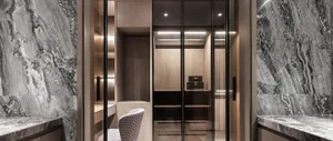 A modern minimalist closet with marble walls and wooden shelves.