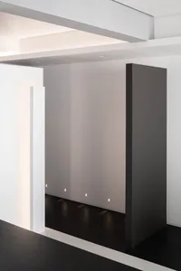 A minimalist office space featuring metallic surfaces and a clean, geometric design.