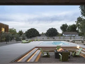 A modern residential space featuring concrete walls and illuminated concrete seating areas.