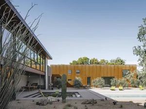 A modern residential house with wooden exterior and a pool in the backyard.