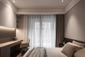 A modern bedroom with a bed, fabric blinds, and desk area