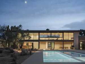 Modern house with glass and concrete exterior at night.