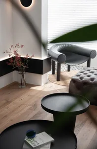 A modern living room with white flooring, wooden tables, and minimalist furniture.