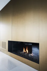 Modern industrial fireplace with metallic and glass materials in minimalist space