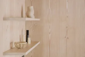 A minimalist wooden bookshelf with various decorative items.