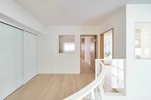 Minimalist white interior with wooden flooring and a modern design.