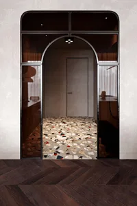 Modern architectural entryway featuring a terrazzo floor with geometric patterns and a large glass window.