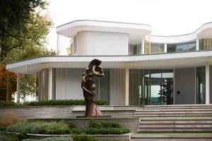 A modern residential exterior featuring concrete and glass materials.