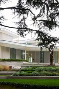 A modern residential exterior featuring light wood and glass.