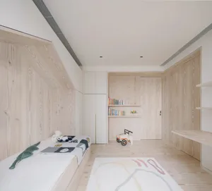 A minimalist children's bedroom with wood paneling, a bed with stuffed animals, and bookshelves.