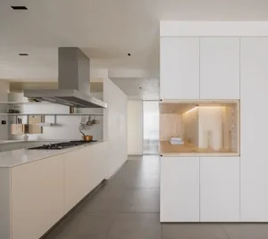 Modern kitchen with minimalist design, white cabinetry, concrete countertops, and timber accents.