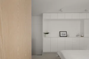 Minimalist residential interior featuring white color scheme, terrazzo flooring, and modern furniture.
