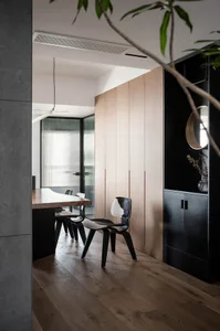Modern dining room with wooden furniture and black and white chairs.