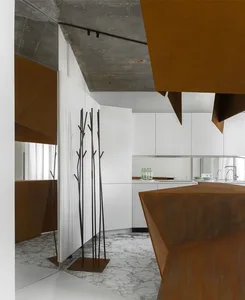 A modern kitchen with metallic accents and white minimalist cabinets.