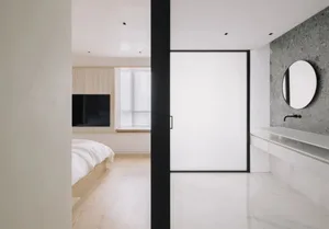 Minimalist bedroom featuring a bed with a wooden frame and a black wooden headboard, a terrazzo floor, and a large window wit