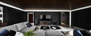 Contemporary living room with grey sofas, black walls, and a large flat-screen TV.