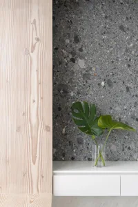 A close-up shot of a modern room featuring white marble, terrazzo, and light wood textures.
