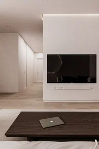 Minimalist living room featuring a wooden table, a television mounted on the wall, and a hallway in the background.