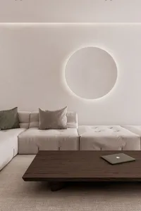 A minimalist living room featuring a modern sofa with a backlit circular design.