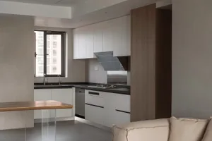 Modern kitchen interior with white cabinets, glass backsplash, and steel appliances.