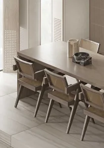 A modern minimalist dining room with a wooden table and marble floor.
